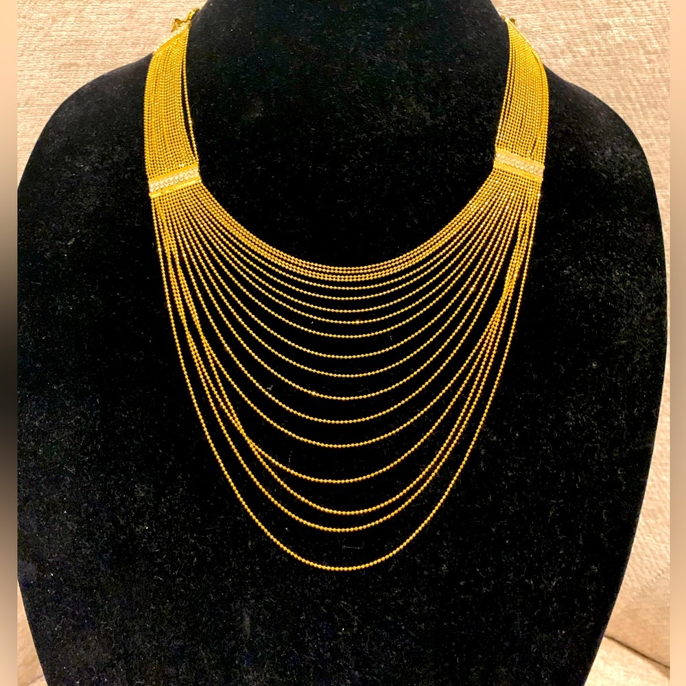 Multi layer bead necklace with bars encrusted with crystals.
